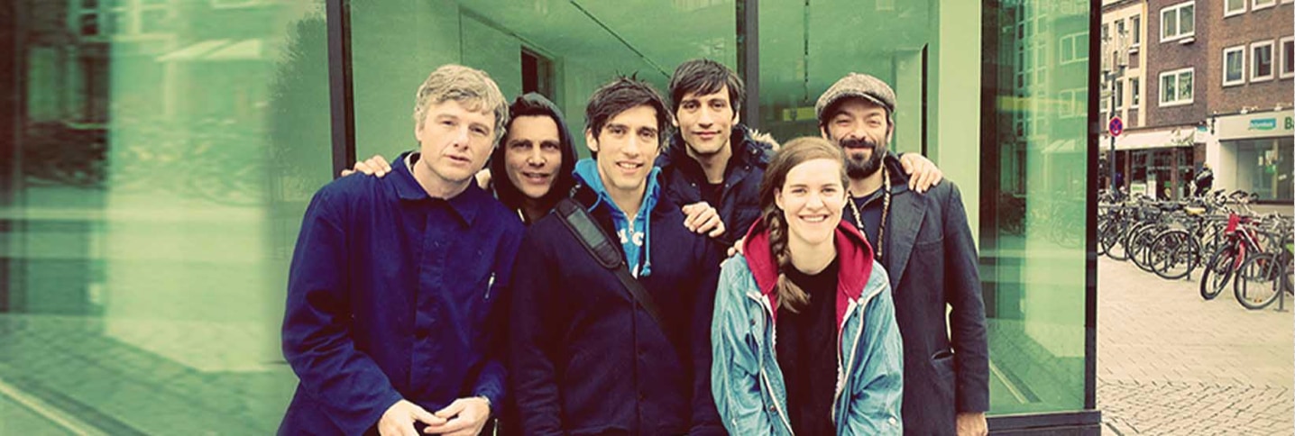 The This Is That touring company together outside a glass-fronted building