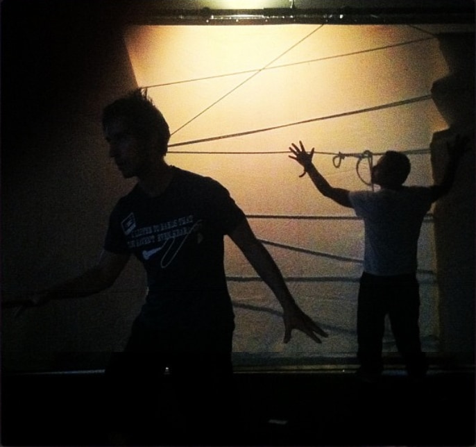 Two performers appearing as shadows on a projected wall
